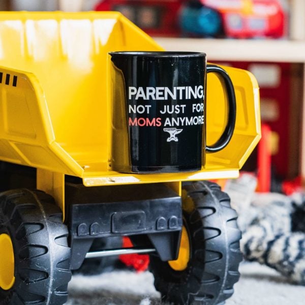 A Parenting, not just for moms anymore mug on a child's dump truck