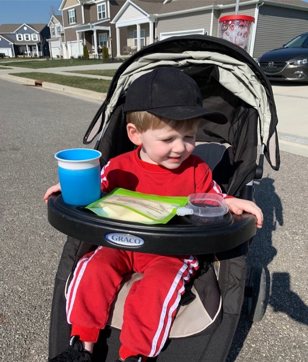 A kid in the Graco FastAction Fold stroller