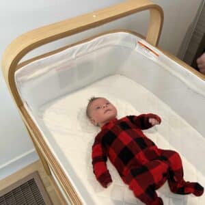 A baby in red pajamas in the Cradlewise Smart Crib