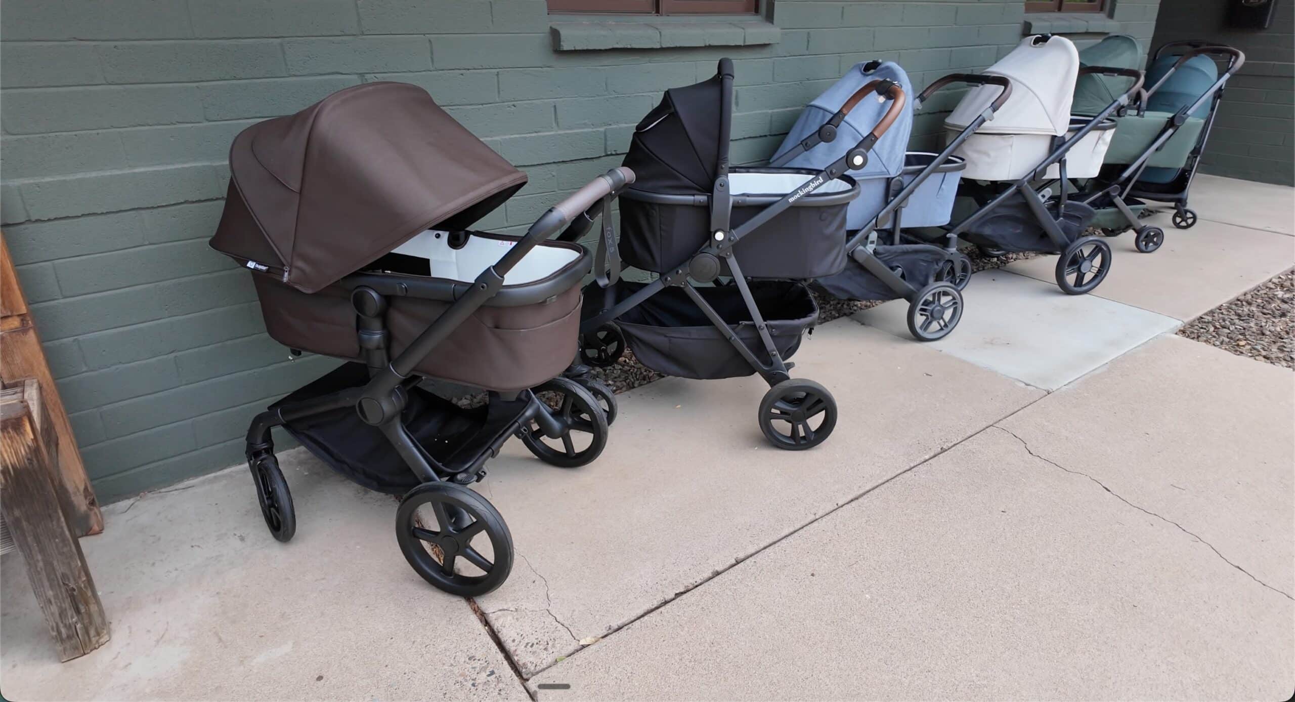 several newborn bassinet strollers int a driveway