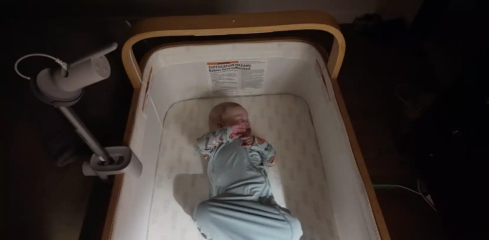Philips Avent camera on a crib pole mount above a bassinet with a sleeping baby